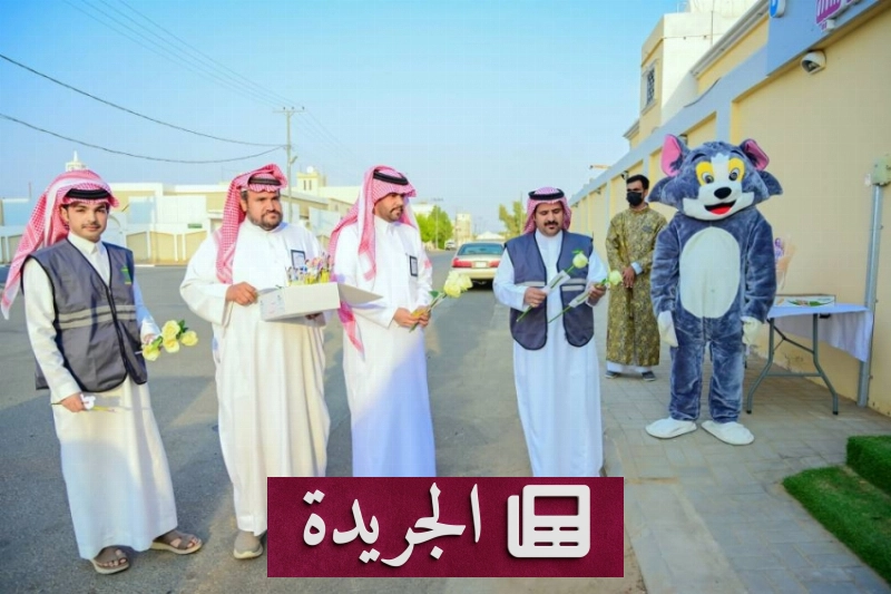 طلاب يستقبلون الهدايا من بلدية الخرمة في بداية العام الدراسي وسط حضور رجال الأمن لتنظيم الحركة المرورية