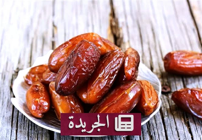 صورة لثمار تمر ناضجة على نخلة، توضح فوائدها الصحية